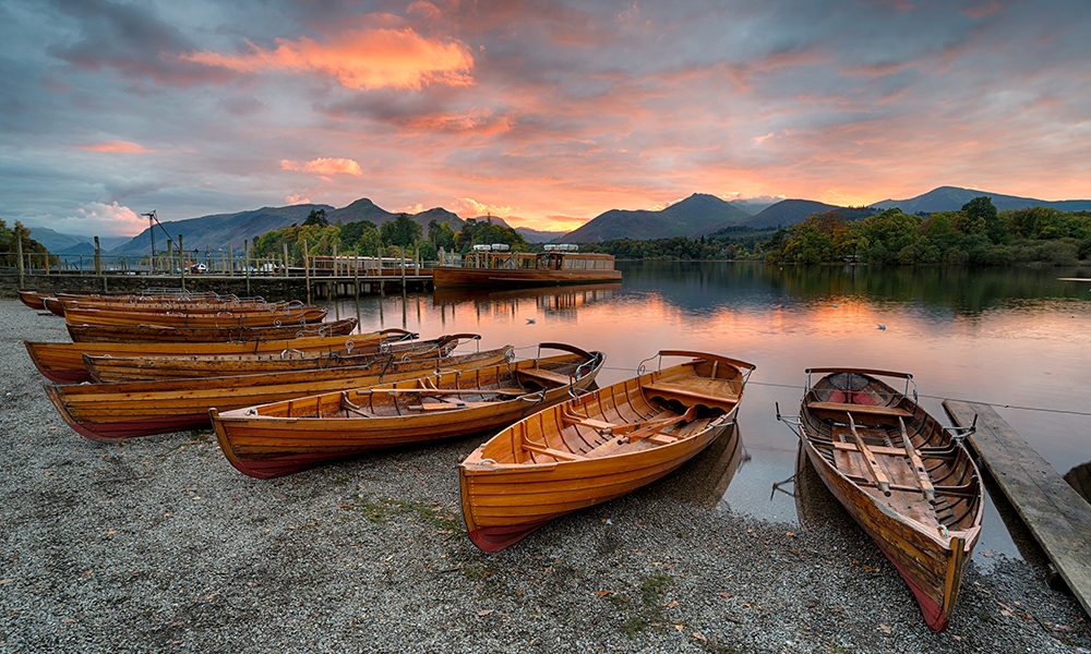 Sunset over wooden boats on the shores of Derwentwater at Keswick in the Lake District national park in Cumbria